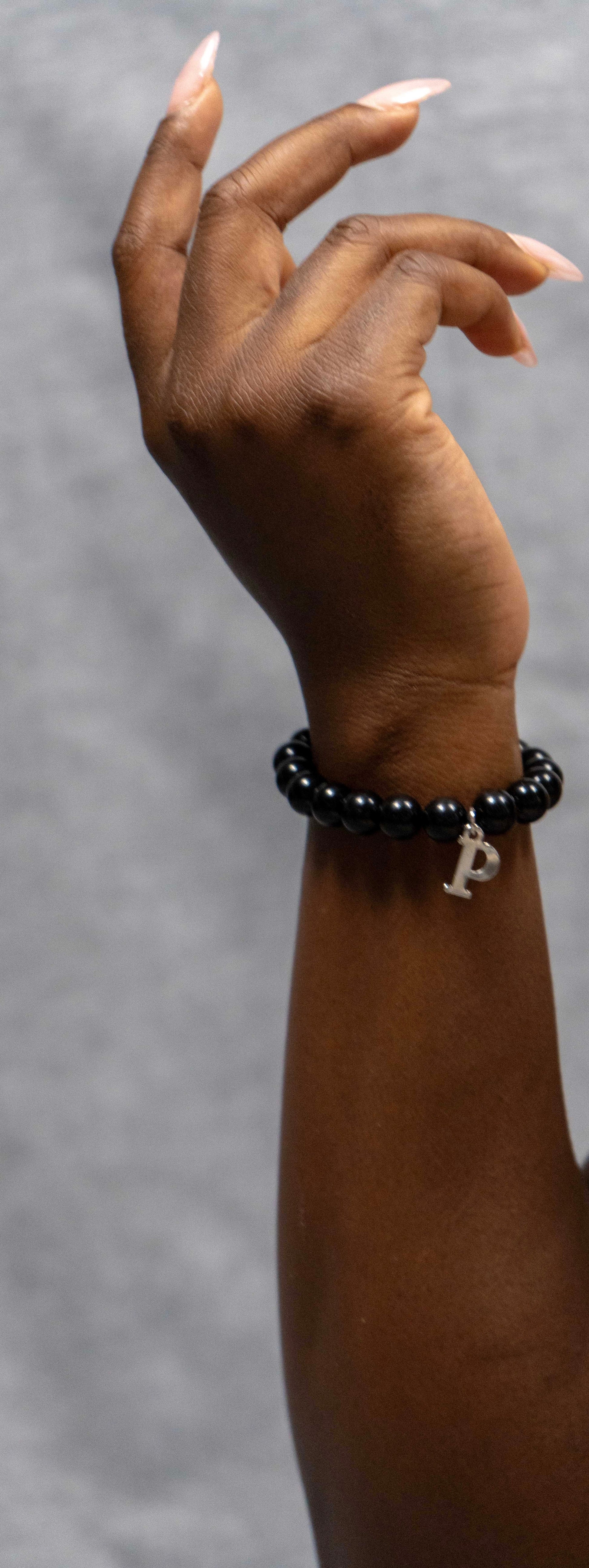 Black beaded bracelet with a charm 